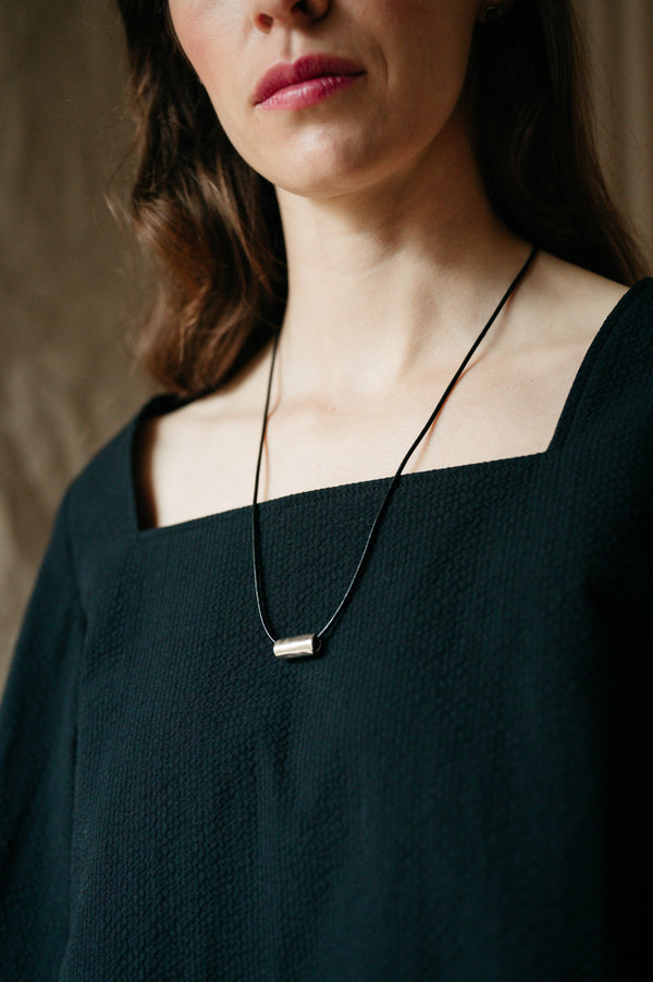 model wearing silver bead pendant 