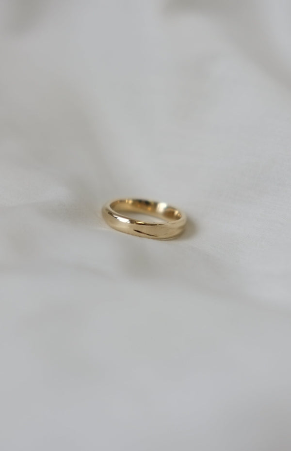 A 9ct gold 4mm fluid band ring on a white background, with a subtle melted texture design.