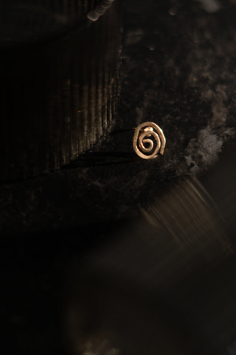 Detailed view of hand-formed spiral shape on unique 9ct gold stud earrings