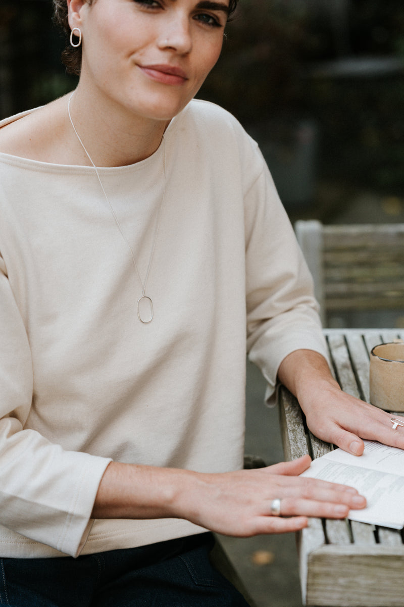 Woman sitting outdoors with a blurred natural background