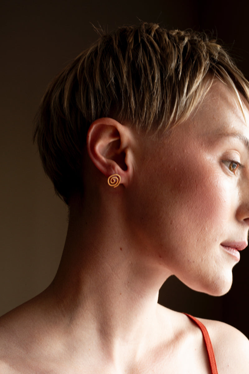 Handmade 9ct gold spiral stud earrings with polished finish and minimalist design