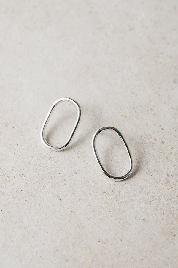 handmade silver oval studs on a grey background