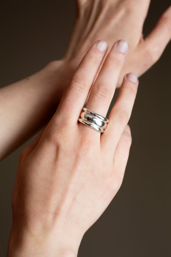 Close-up of open gap design on wide silver ring with polished finish on a hand
