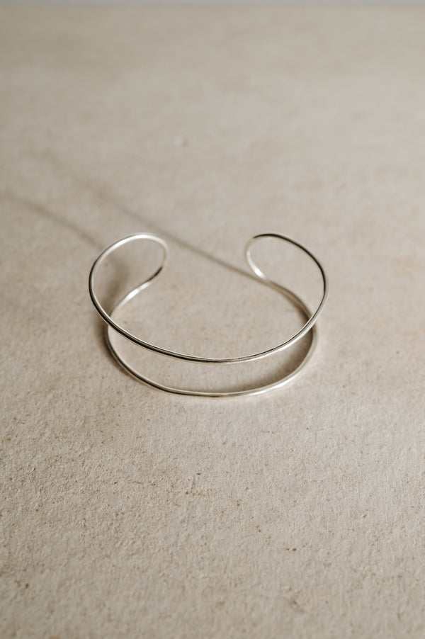 Detail of open feature gap and satin finish on sculptural silver cuff bracelet