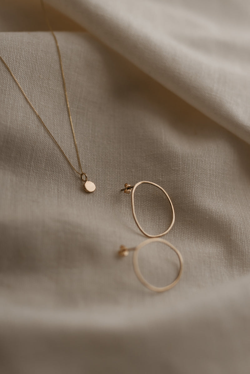 Studio Adorn free-formed gold oval earrings and zero waste gold pebble necklace