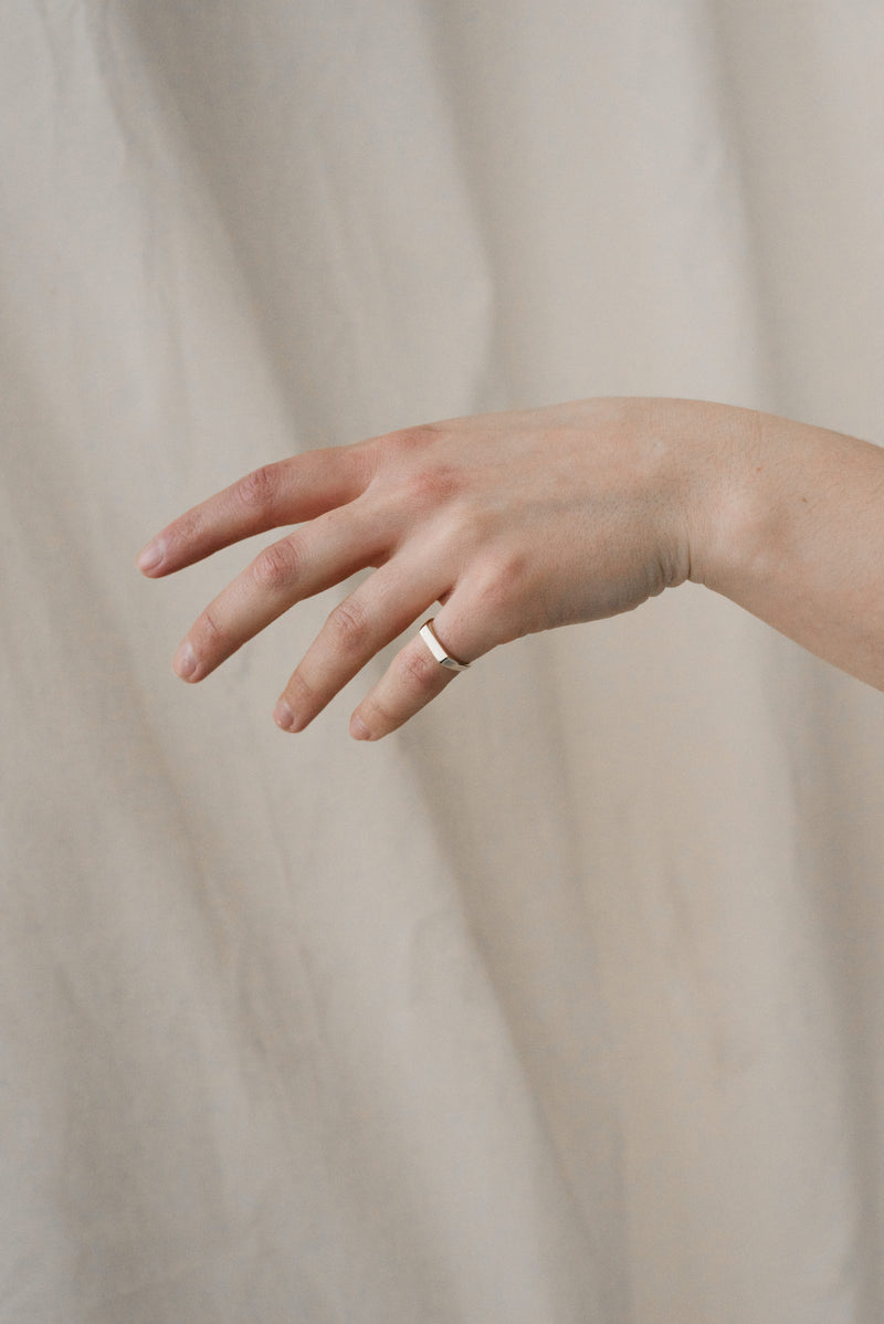 Model wearing solid silver signet ring handcrafted by Studio Adorn