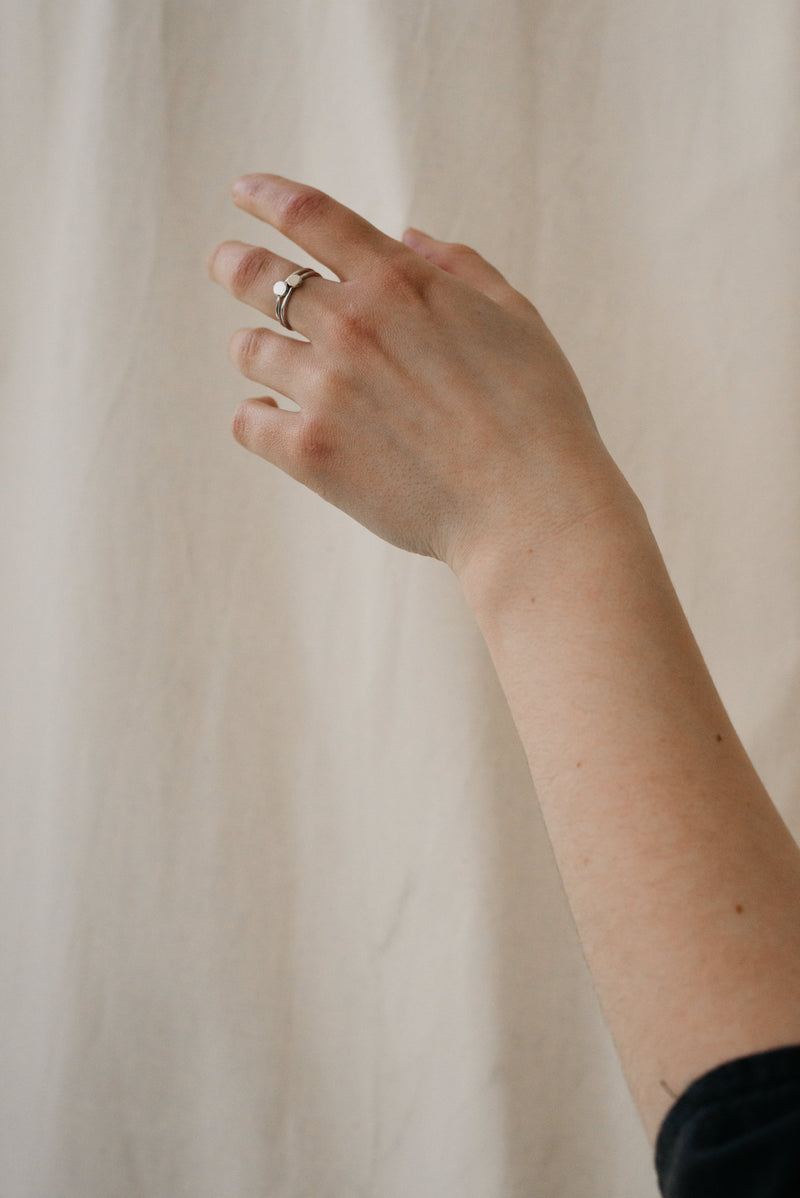 Model wearing eco-friendly stackable rings in solid gold and silver handmade by Studio Adorn