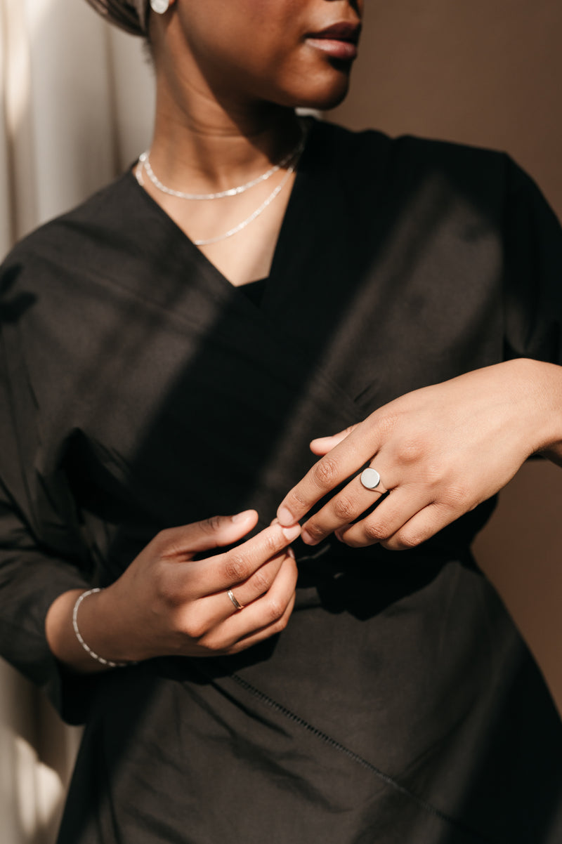 woman wearing round silver signet ring