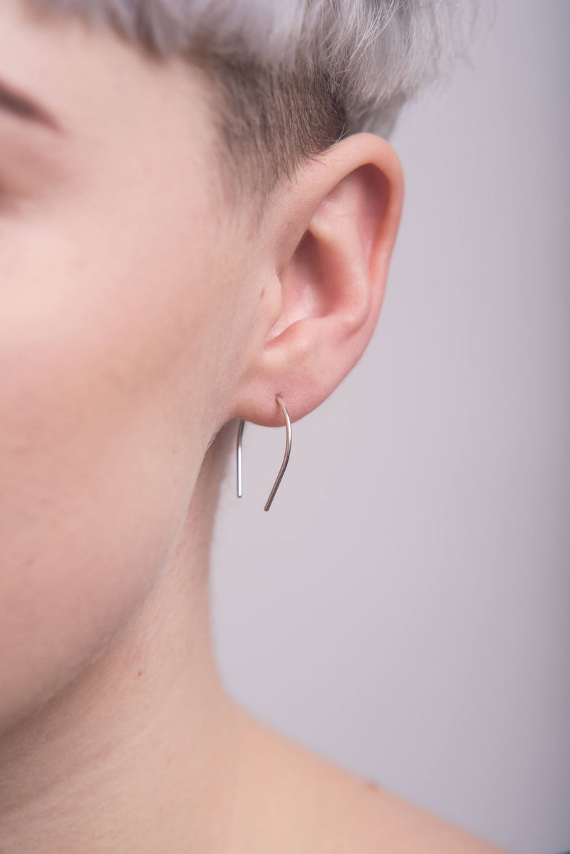 Model wearing silver curve ear pin threads handmade by Studio Adorn