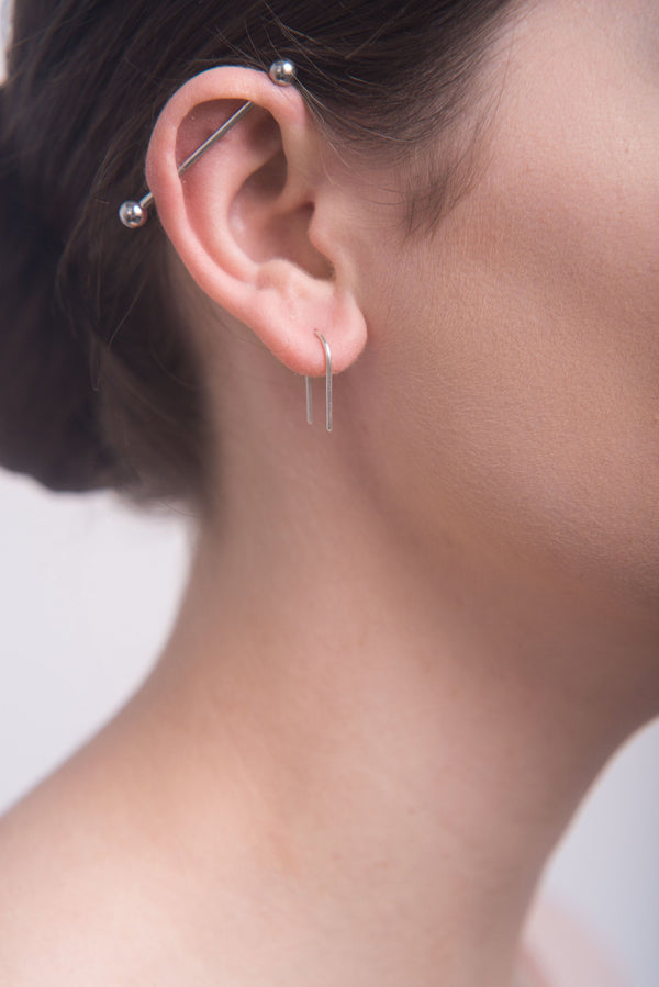 Model wearing silver arch ear pins handmade by Studio Adorn