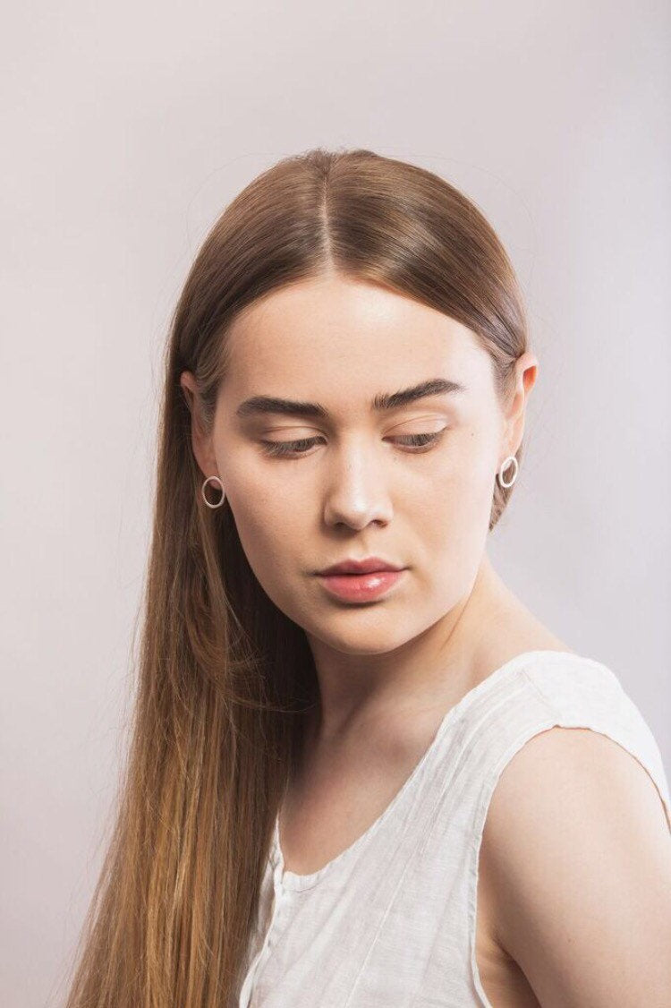 Model wearing simple round silver stud earrings handmade by Studio Adorn