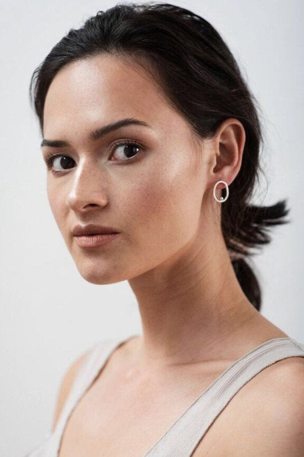 Model wearing open circle silver stud earrings handmade by Studio Adorn