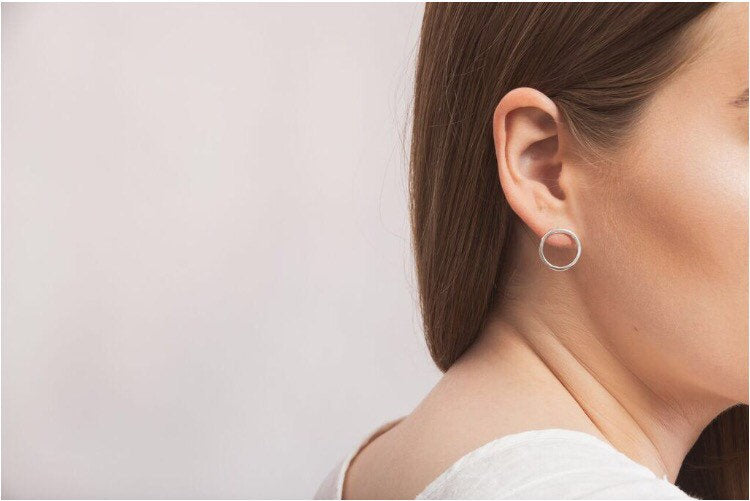 Model wearing simple round silver stud earrings handmade by Studio Adorn