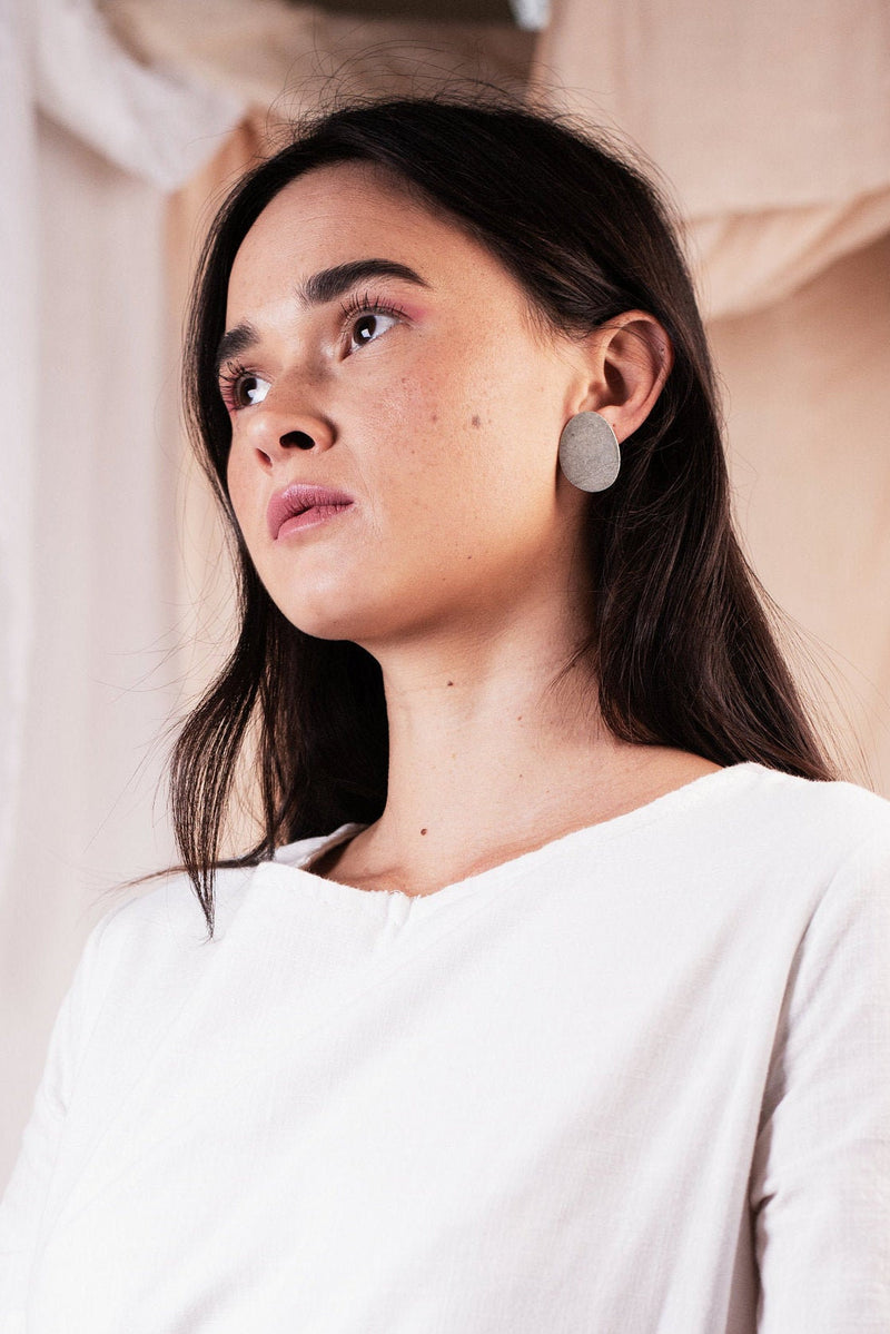 Model wearing statement organic shape silver stud earrings handmade by Studio Adorn