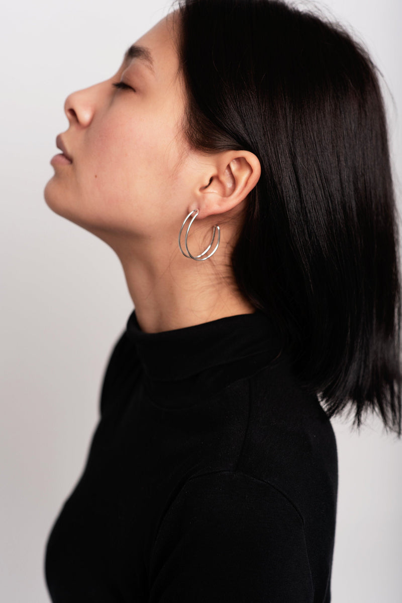 Model wearing silver loopy hoop earrings handmade by Studio Adorn