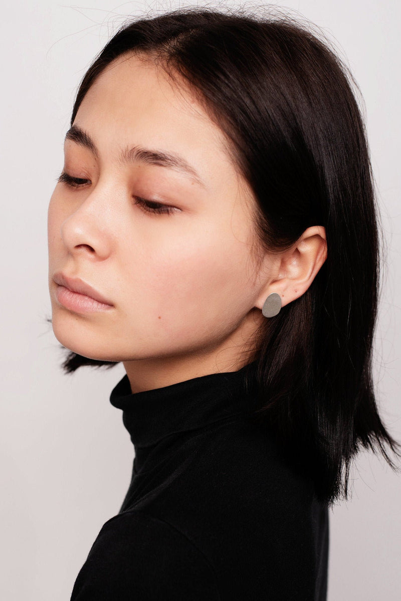 Model wearing mini organic shape stud earrings handmade by Studio Adorn