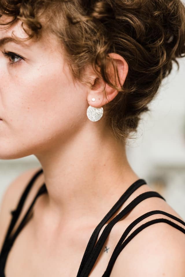Model wearing Silver hammered disc ear jacket earrings handmade by Studio Adorn