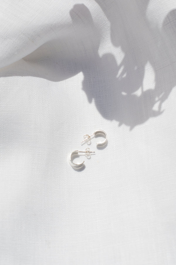 Mini hammered huggy hoop silver earrings handmade by Studio Adorn