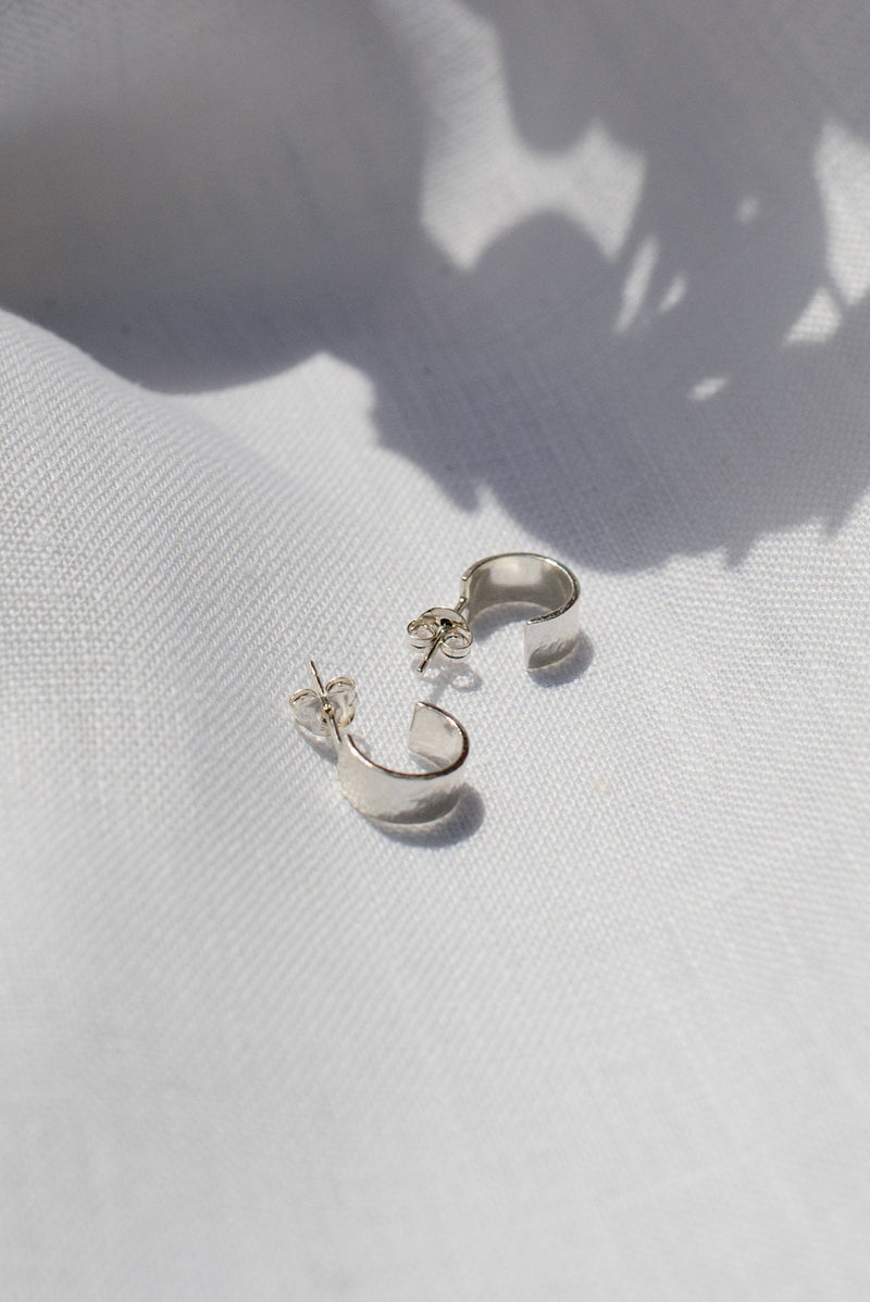Mini hammered huggy hoop silver earrings handmade by Studio Adorn