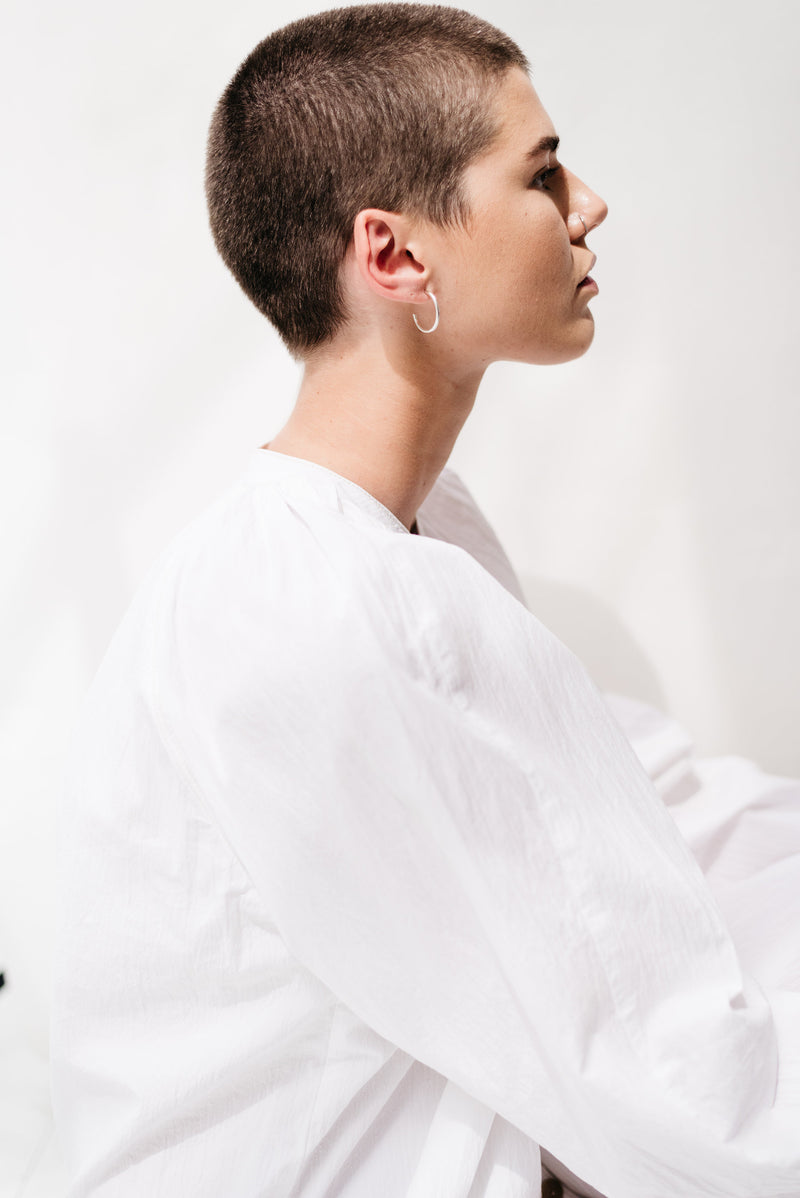 Model wearing large silver minimal hoop earrings handmade by Studio Adorn