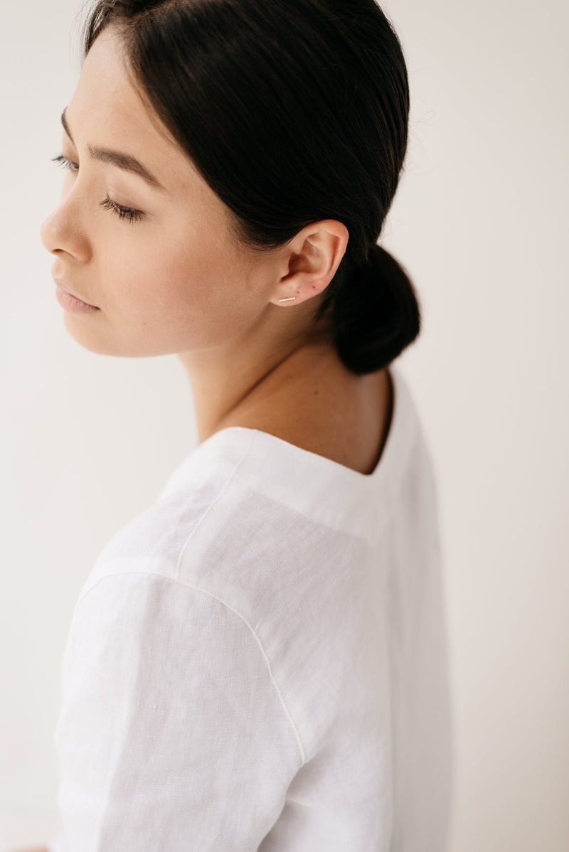 Studio Adorn side profile of model wearing delicate 9ct gold bar studs earrings