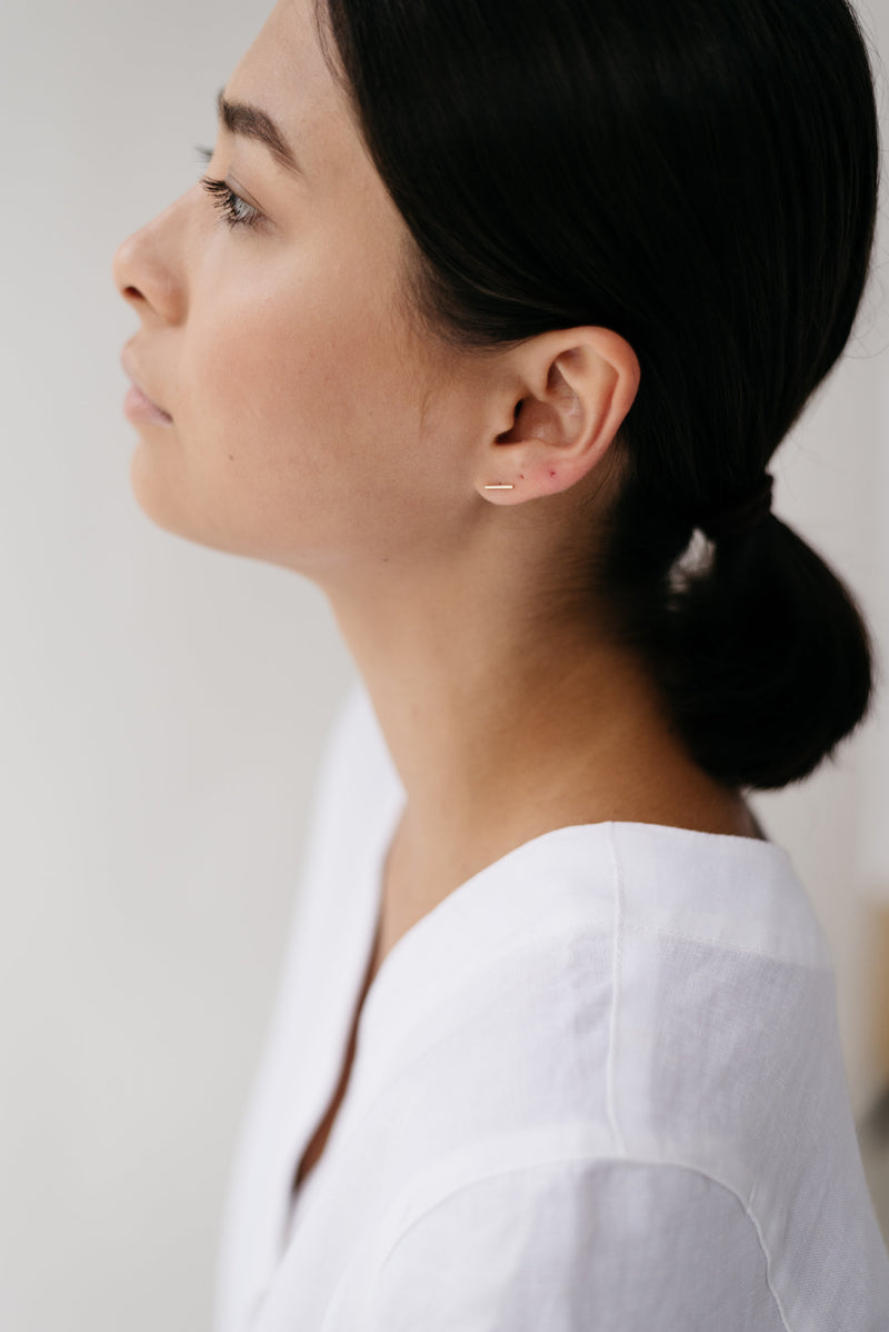 Studio Adorn side profile of model wearing recycled gold bar stud earrings 