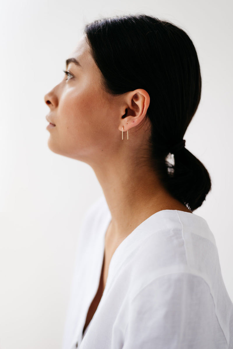 Studio Adorn side profile of model wearing minimalist 9ct gold ear pins