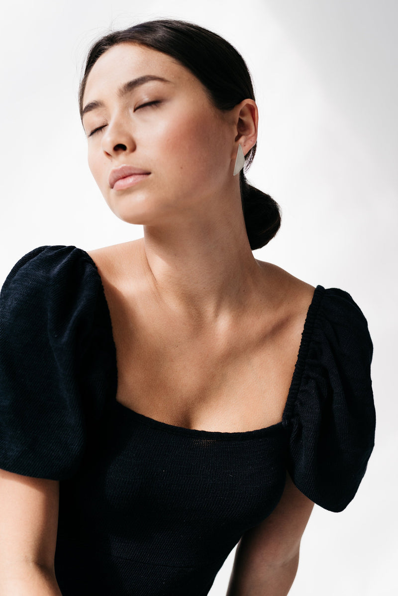 Model wearing mismatched silver statement earrings handmade by Studio Adorn