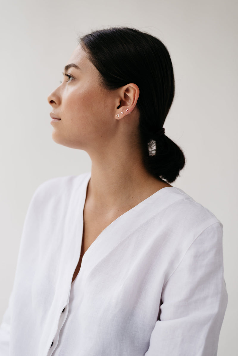 Model wearing Trio of mini silver stud earrings handmade by Studio Adorn
