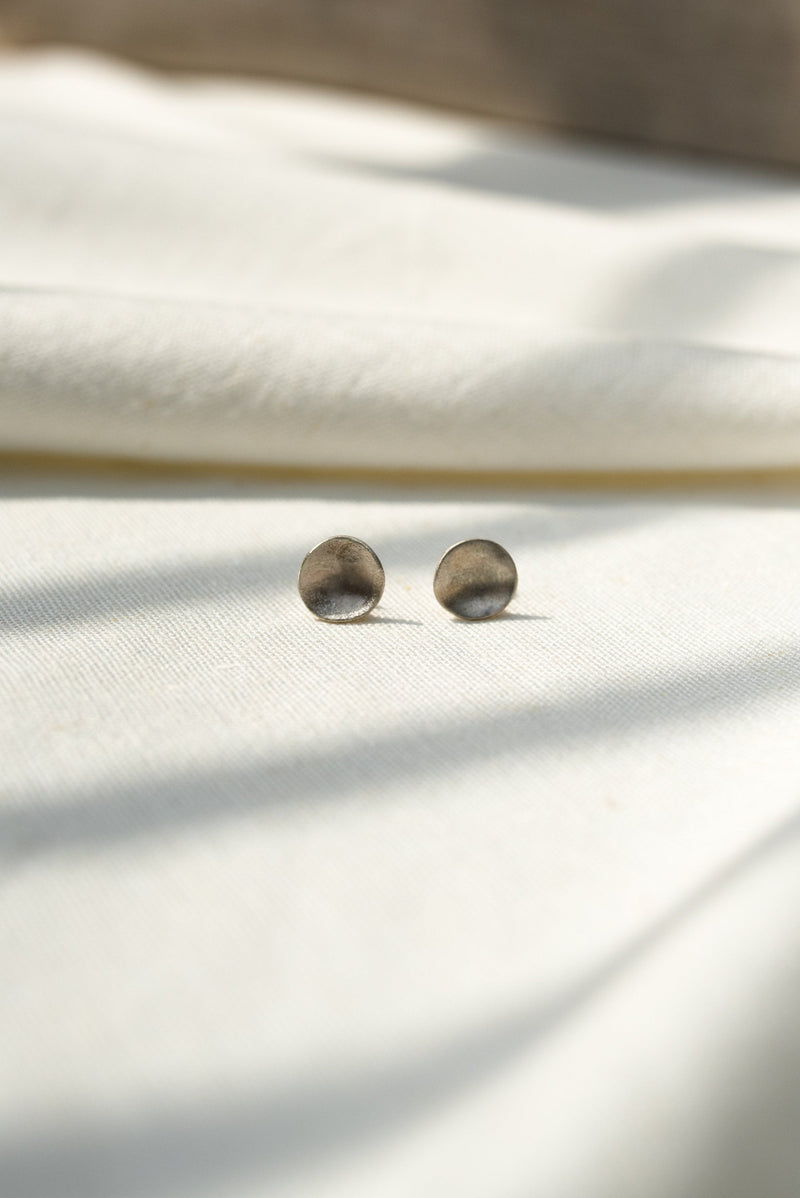 Mini molten silver stud earrings handmade by Studio Adorn