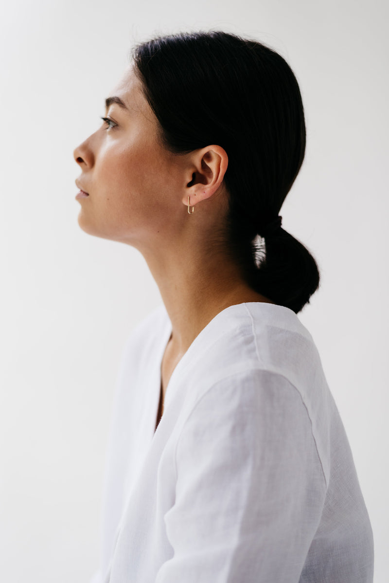 Studio Adorn side profile of model wearing delicate 9ct recycled gold curl studs 