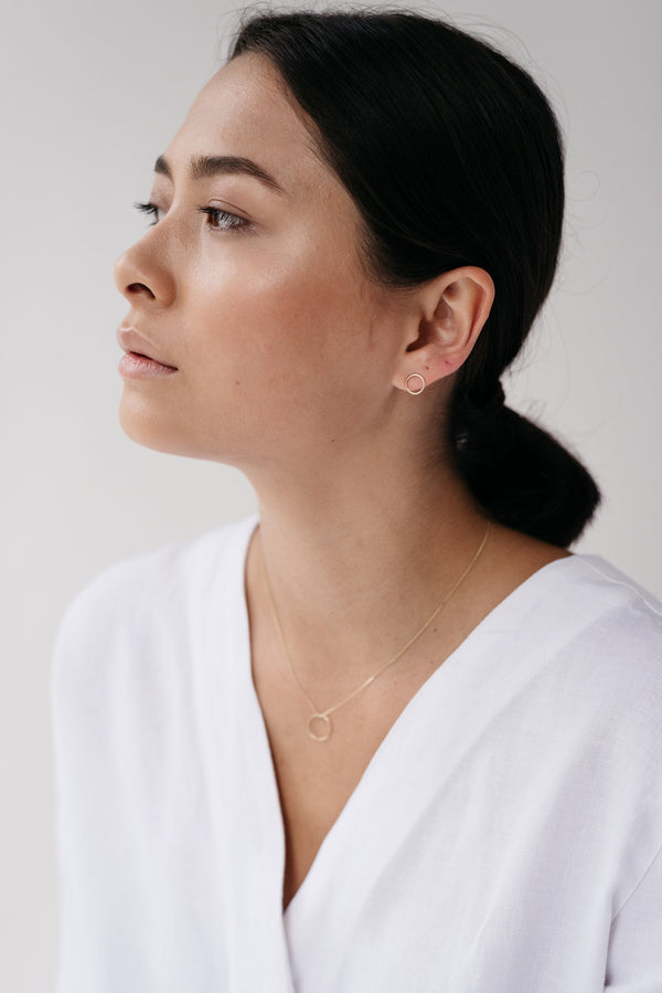 Studio Adorn side profile of model wearing 9 carat recycled gold open circle earrings and 9ct mini open circle necklace