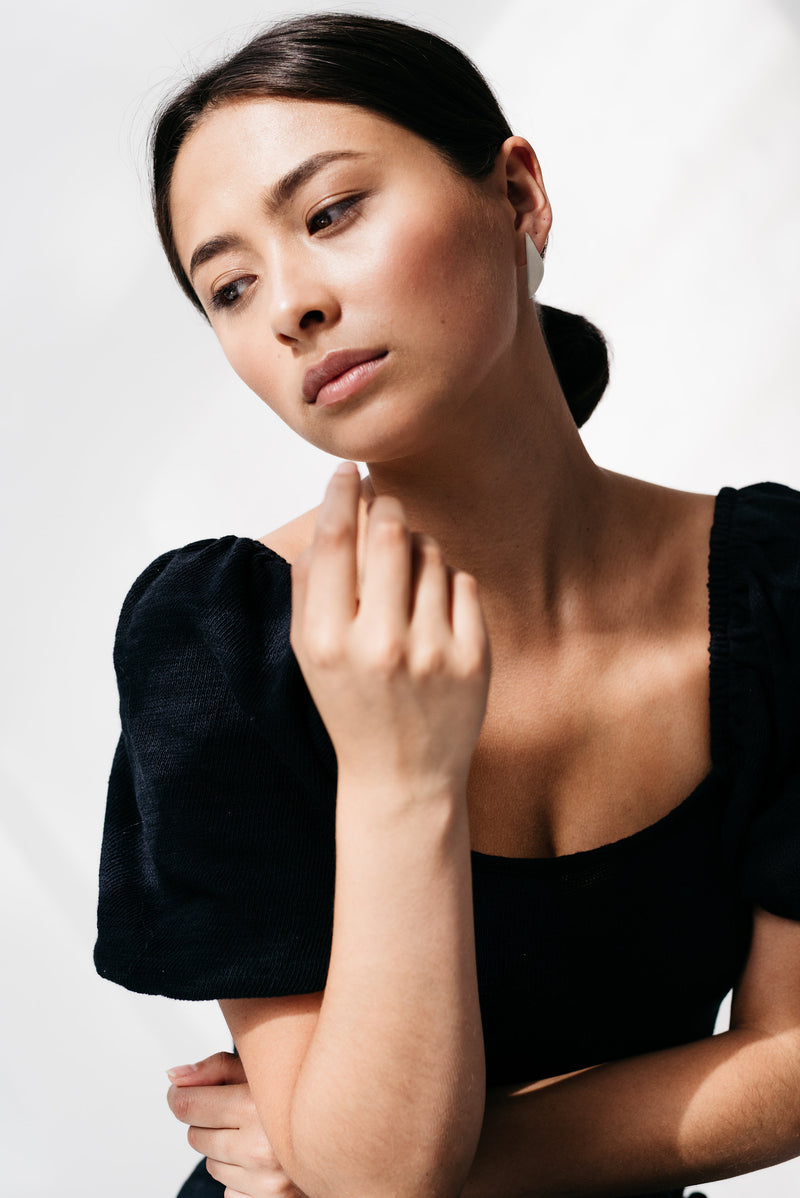 Model wearing mismatched silver statement earrings handmade by Studio Adorn