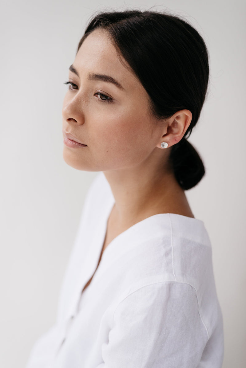 Model wearing mini molten silver stud earrings handmade by Studio Adorn