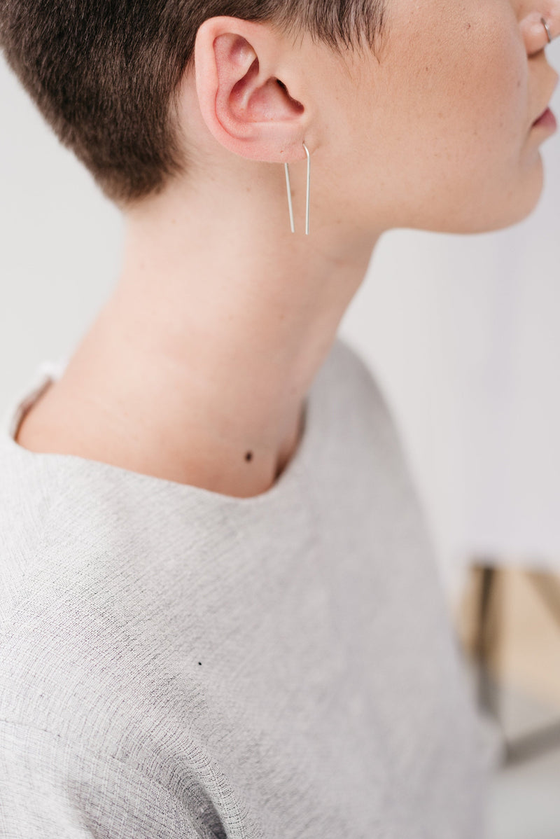 Model wearing long silver ear pin threads handmade by Studio Adorn