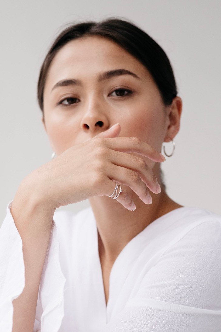 Model wearing plain hammered stacking ring in silver handcrafted by Studio Adorn