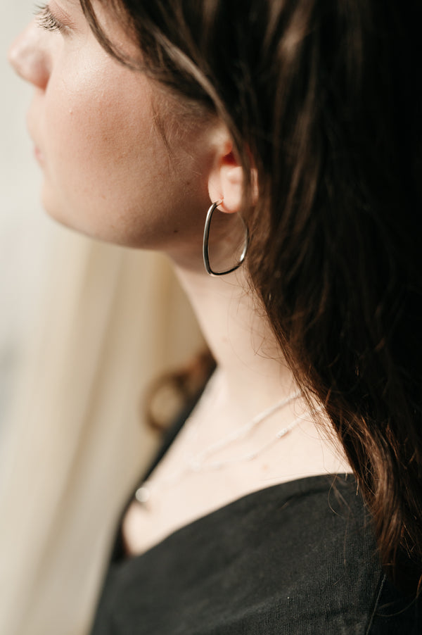 woman wearing statement silver hoops