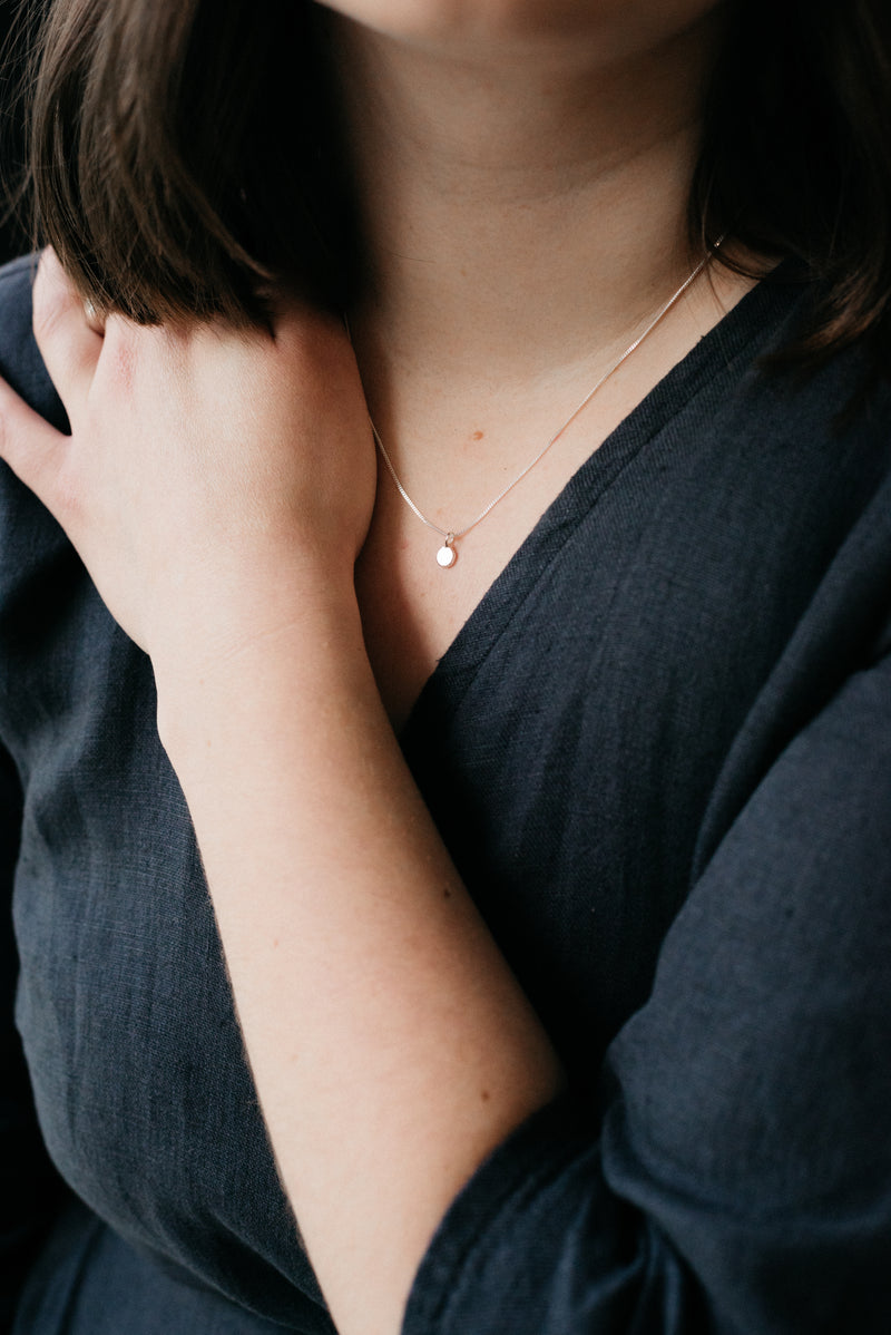 Model wearing sustainable and ethical silver pebble pendant necklace handmade by Studio Adorn