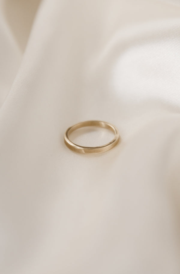 a simple, modern 2mm square wire wedding band handmade in 9ct gold on a white background