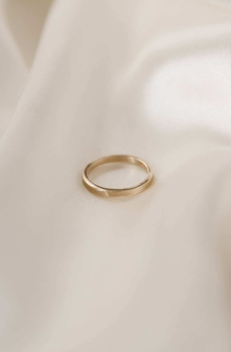 a simple, modern 2mm square wire wedding band handmade in 9ct gold on a white background