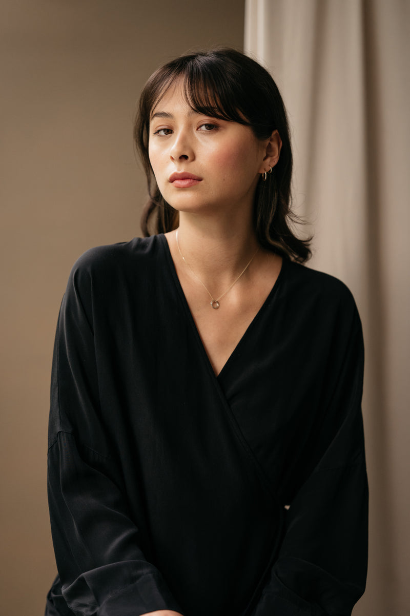 women wearing a mixed metal russianknot necklace against a beige background